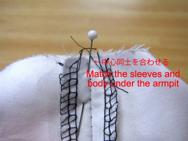 Fastening the sleeve securely with pins to attach it to the armhole