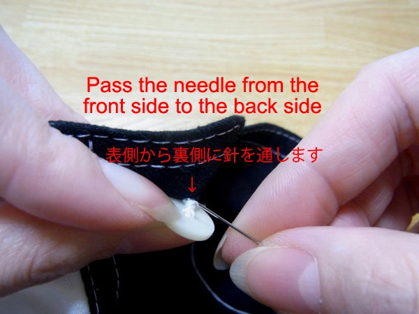 Passing the needle from front to back of fabric