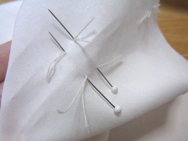 Inserting pin through dart marks