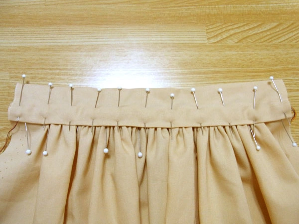 Using marking pins to secure thick gathered fabric for sewing