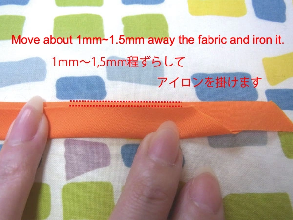 Folding bias tape slightly off-center and ironing